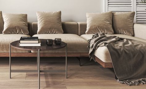Living room with a sofa sculpted glass coffee table and fur throw pillows (Demo)